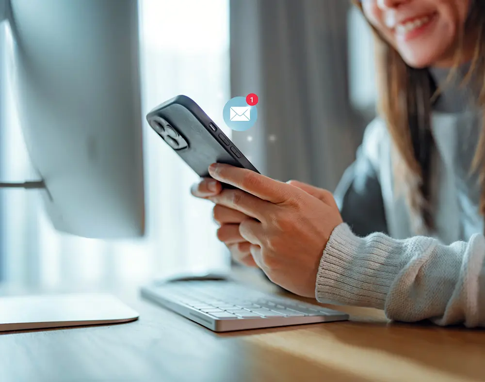 Frau mit Smartphone in der Hand erhält eine E-Mail