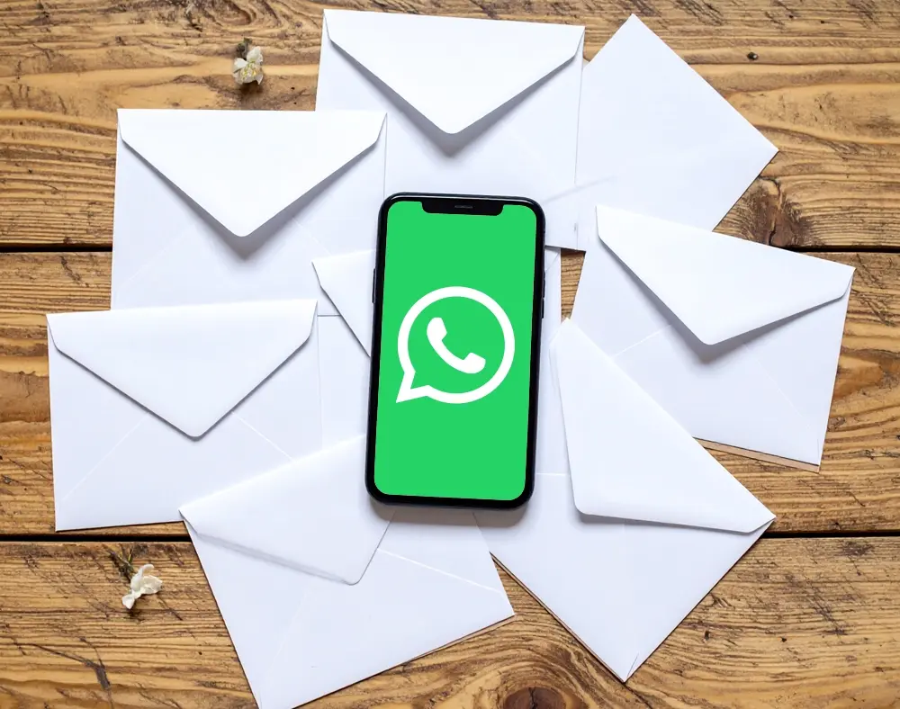 WhatsApp auf einem Handy auf einem Tisch voller Briefe